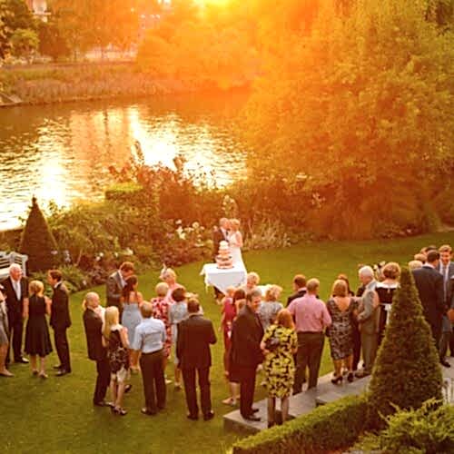 wedding festivities taking place on a riverside at sunset