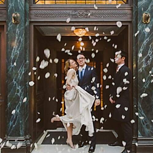 confetti being thrown on a couple during a wedding ceremony