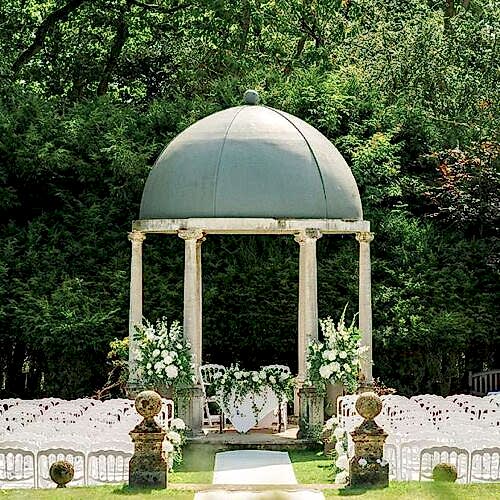 An outdoor wedding ceremony event space with pergola