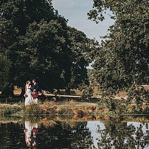 A newly married couple walking past a river