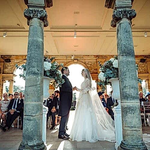 Couple exchanging vows in from of arched door space